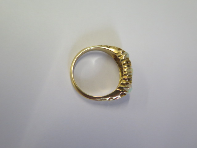 An 18ct yellow gold three stone opal ring set with small diamonds - ring size N - approx weight 4. - Image 3 of 4