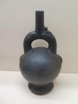 A Pre-Columbian or later black ware pottery stirrup pot with bird detail, crack to base, possible