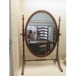 A mahogany oval dressing mirror on stand - Height 69cm x Width 49cm