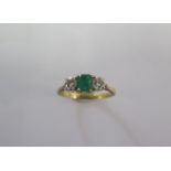 A hallmarked 18ct yellow gold diamond and emerald three stone ring size M/N - approx weight 2.8