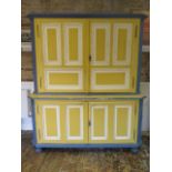 A 19th century continental painted pine two part cupboard on cupboard with panelled doors ad sides -