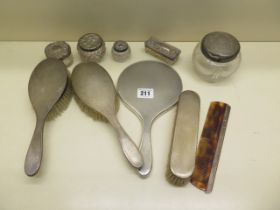 A collection of five silver top bottles and five silver back dressing table brushes, mirror and comb