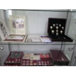 A collection of assorted commemorative coins and other coins and coin trays
