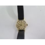 A 9ct yellow gold manual wind ladies wristwatch 18mm case on a leather strap
