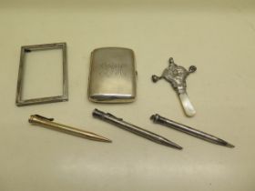 A silver cigarette case, a silver pencil and two other pencils, a silver frame surround and a silver