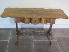 A walnut three drawer dropleaf stretcher table with a shaped top - Height 73cm x 197cm x 55cm