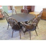 An Ercol drop leaf dining table - Height 72cm x 128cm x 140cm extended with six stick back chairs