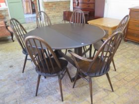 An Ercol drop leaf dining table - Height 72cm x 128cm x 140cm extended with six stick back chairs