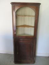 A Georgian oak two part corner cupboard with a base door and painted interior - Height 184cm x Width