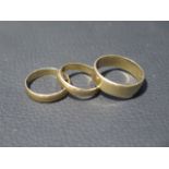Three 9ct yellow gold wedding bands sizes R/S, M & L - total weight approx 7.9 grams