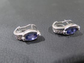 A certified pair of 18ct white gold earrings set with oval tanzanite's and round brilliant cut