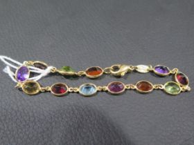 An 18ct yellow gold bracelet set with twelve coloured semi-precious stones including amethyst,