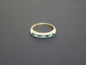 A 9ct yellow gold bridge ring with four emeralds - ring size N - weight approx 1.8 grams