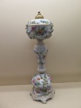 A Continental floral encrusted porcelain oil lamp stand - Height 61cm - some foliate losses and