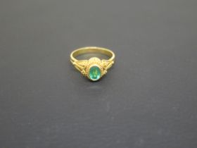 A yellow metal ring marked K22 and tested as such with green tourmaline - ring size T - approx