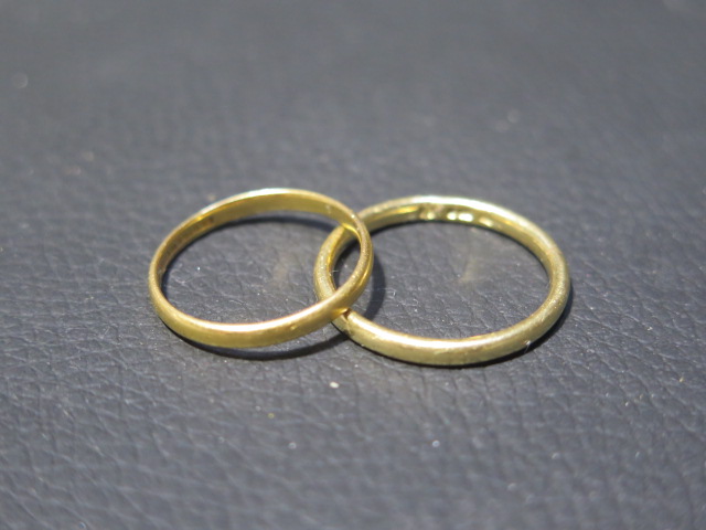 A 22ct yellow gold wedding band size P - weight approx 2.1 grams - together with an 18ct yellow gold