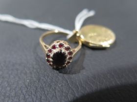 A small 9ct yellow gold locket - approx 1.5cm together with a 9ct yellow gold and red garnet ring