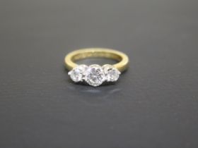 A three stone diamond ring - the central stone approx 0.6ct - set in 18ct yellow gold - ring size