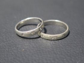 Two 9ct white gold bands each set with three small diamonds - ring sizes S/T & N - total weight