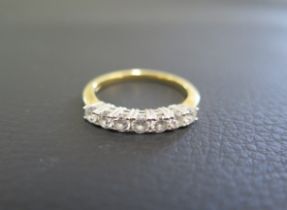 An 18ct gold seven stone diamond ring size Q - in good condition, diamonds bright