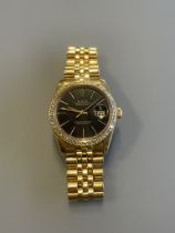 A gents Rolex Datejust in 18ct yellow gold, black dial with diamond bezel, with Rolex 18ct gold