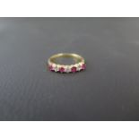 An 18ct yellow gold ruby and diamond bridge ring size Q/R - weight approx 3.3 grams