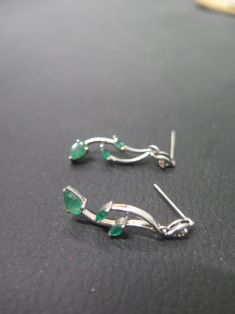 A pair of 18ct white gold and emerald earrings - three emeralds set in leaf shape - approx 3.5cm -