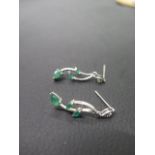 A pair of 18ct white gold and emerald earrings - three emeralds set in leaf shape - approx 3.5cm -