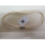 A triple string pearl necklace with 9ct yellow gold clasp with pearls and rubies