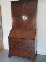 A good quality early 19th century flame mahogany bureau bookcase with two doors above the base which