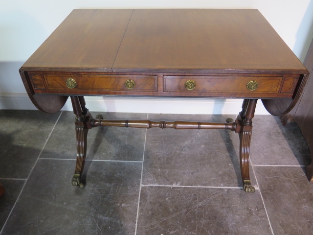 A 19th century mahogany drop leaf sofa table with two active and two dummy drawers on twin pillar