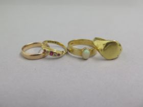 Four 18ct yellow gold rings - a wedding band size O/P, an opal ring size V, ruby ring size N/O and a