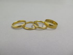 Four 22ct yellow gold wedding bands - sizes R,P,M/N & K/L - total weight approx 17.2 grams