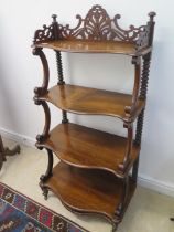 A 19th century rosewood four tier whatnot with a fretwork top and scroll supports - in good