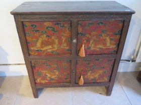 A Tibetan hand painted panelled cabinet decorated with tigers and leopards with two small doors