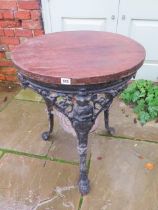 A cast iron pub table with a wooden top