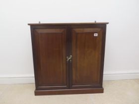 A mahogany two door table/mantle top cabinet with two shelves and compartment, lock and key - approx