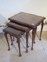 A modern nest of three walnut tables