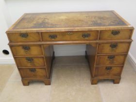 A good quality late 19th century walnut nine drawer knee hole desk with a leather inset top -