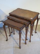 A modern nest of three walnut tables