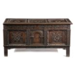 AN OAK COFFER 17TH CENTURY AND LATER with a triple panelled lid above a strapwork frieze, with a