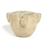 A MARBLE APOTHECARY MORTAR PROBABLY 14TH / 15TH CENTURY of rounded form, carved with four masks to
