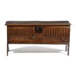 A BOARDED ELM COFFER WEST COUNTRY, EARLY 18TH CENTURY the hinged lid with a moulded edge, above an