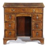 A WALNUT KNEEHOLE DESK EARLY 18TH CENTURY AND LATER with feather banding, the crossbanded rosewood