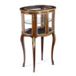 A FRENCH MAHOGANY OVAL VITRINE LATE 19TH CENTURY with ormolu mounts, the top with a bevelled glass