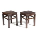 A PAIR OF CHINESE STAINED ELM LOW STANDS 19TH CENTURY each with a panelled top on scroll feet (2)