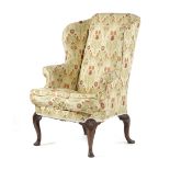 A GEORGE II WALNUT WING ARMCHAIR C.1730-40 with later upholstery, with scroll arms on shall capped