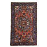 A TAFRISH RUG PERSIAN / KURDISTAN, C.1940 the brick red field with typical indigo and salmon pink