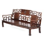 A CHINESE PADOUK SETTEE QING DYNASTY the open scroll work back centred with a carved shou character,