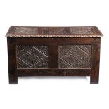 A CARVED OAK COFFER IN 17TH CENTURY STYLE with relief carved panels of leaves, flowerheads and